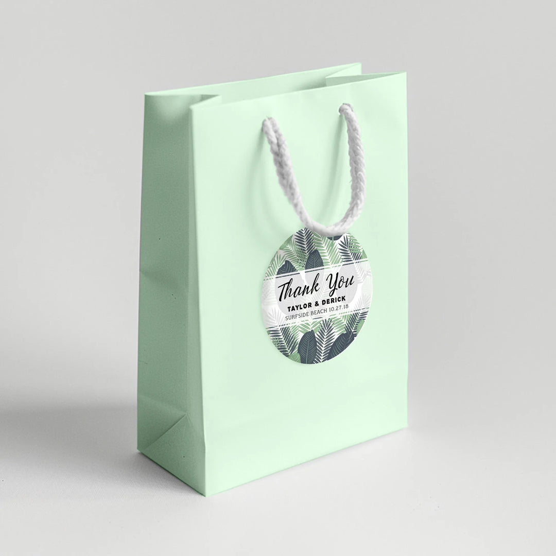 Mint green wedding favor bag with tropical leaves thank you label and white rope handle