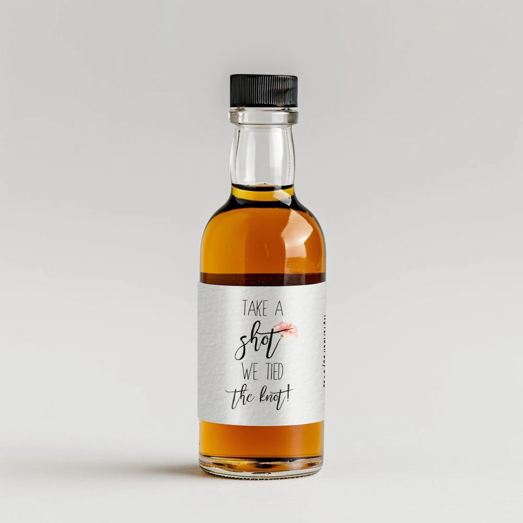 Mini liquor bottle with custom wedding label reading 'Take a shot we tied the knot'