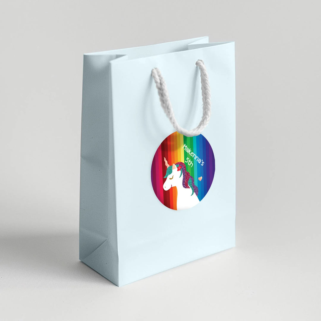 Unicorn rainbow birthday favor label on white gift bag with rope handle