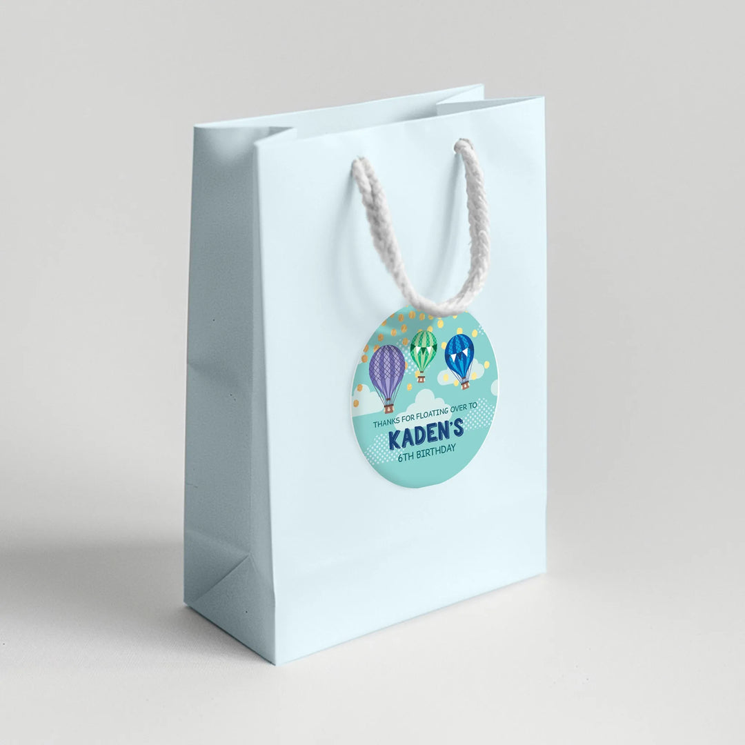 Light blue birthday favor bag with colorful hot air balloon label for Kaden's 6th birthday