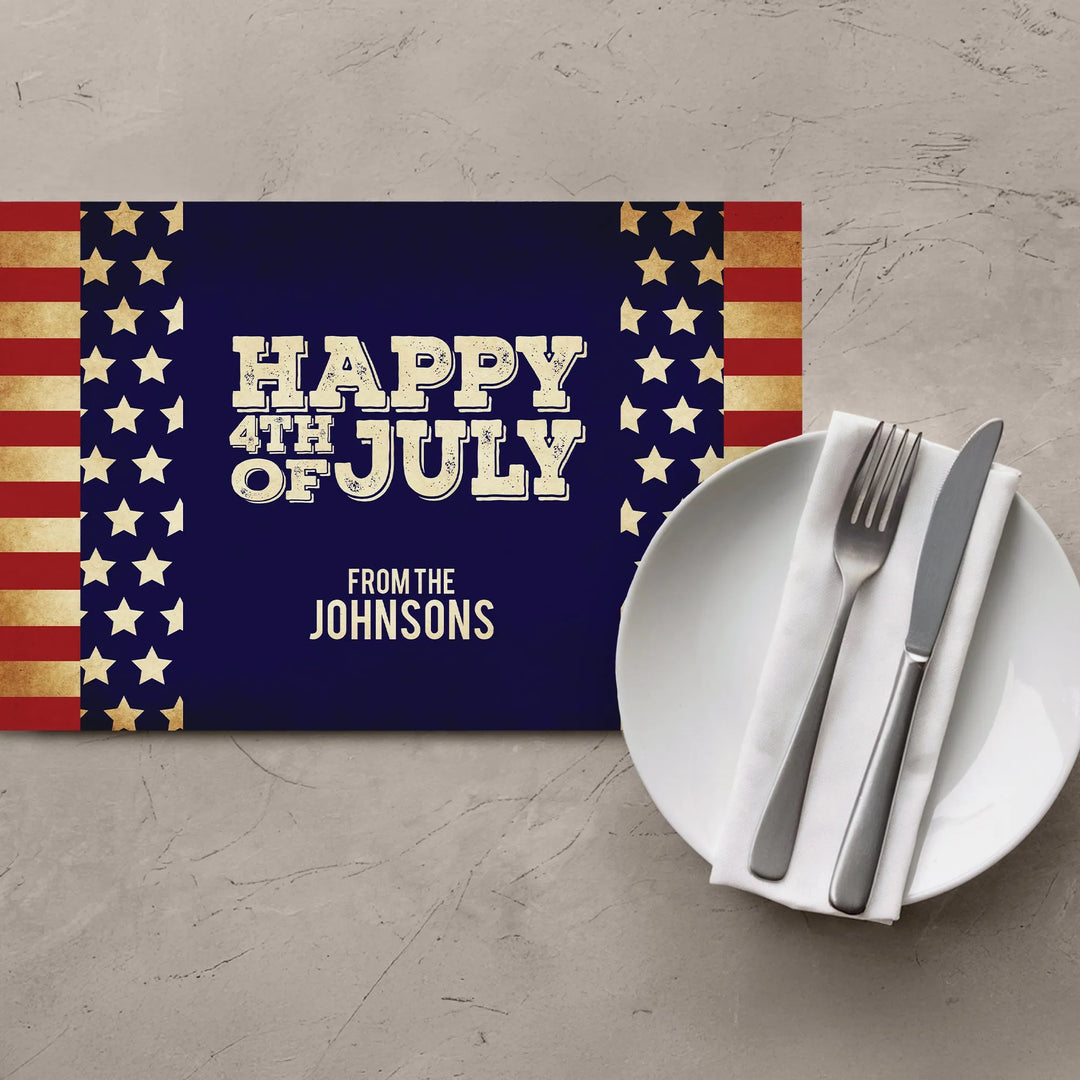 Vintage July 4th placemat with stars, stripes, plate and cutlery on a table.