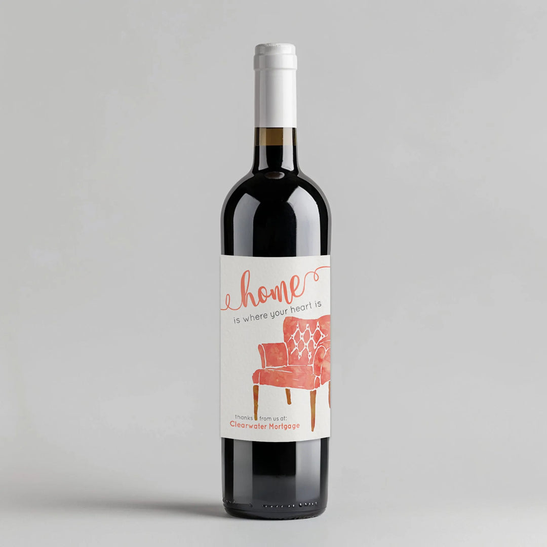 Wine bottle with watercolor chair label reading 'home is where your heart is,' mortgage broker gift
