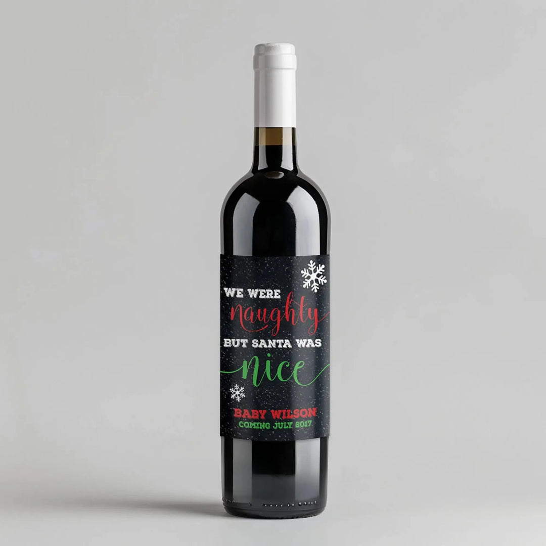 Wine bottle with custom Christmas label reading 'We were naughty but Santa was nice', snowflake design