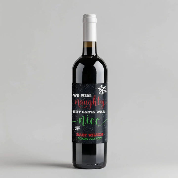 Wine bottle with custom Christmas label reading 'We were naughty but Santa was nice', snowflake design