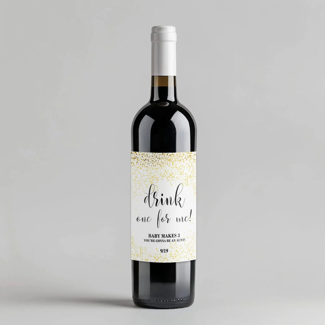 Wine bottle with white label reading 'drink one for me!' and gold confetti design