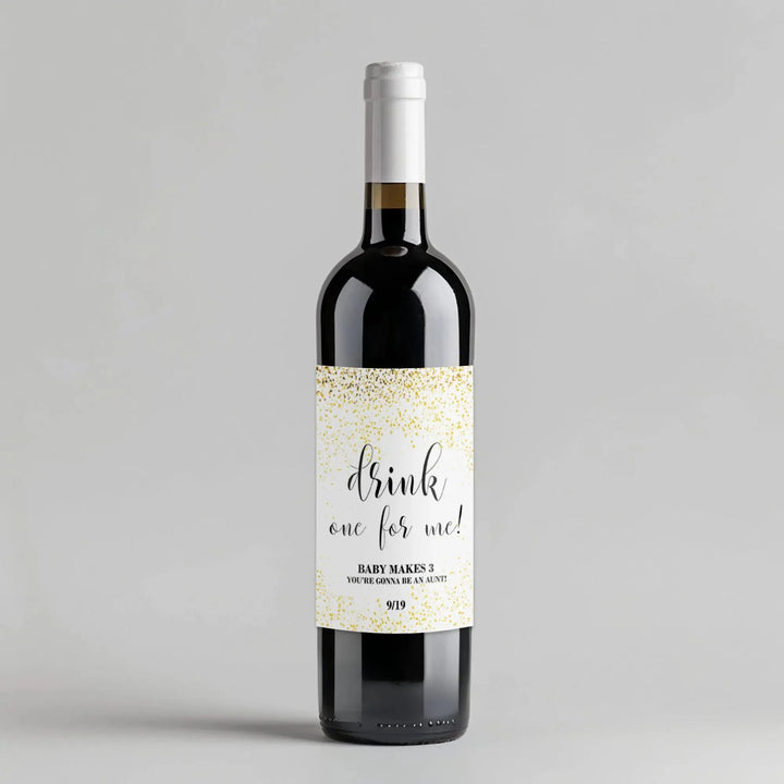 Wine bottle with white label reading 'drink one for me!' and gold confetti design