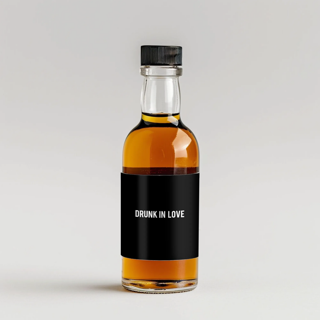 Mini liquor bottle with black label reading 'Drunk In Love' on white background