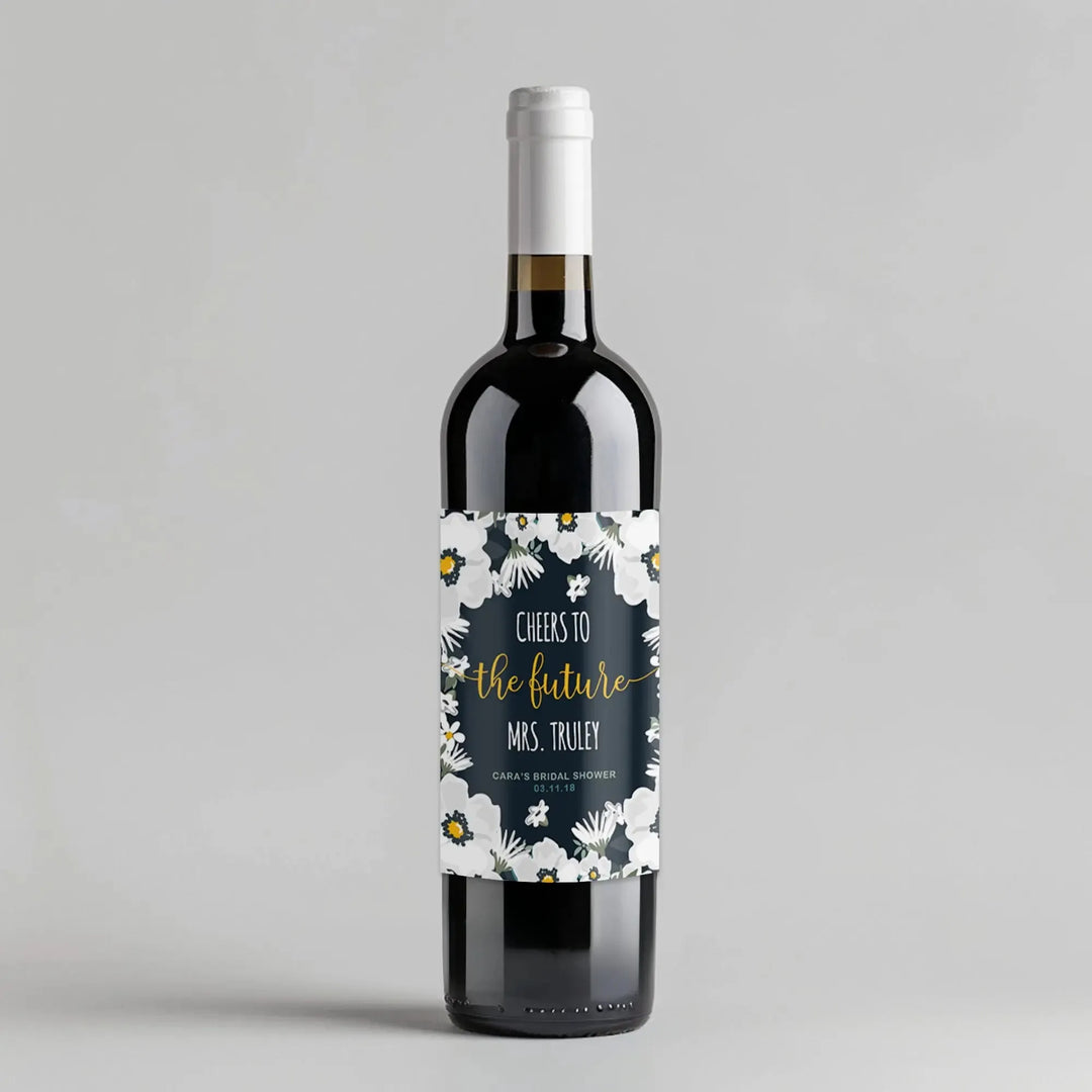 Wine bottle with white floral bridal shower label and 'cheers to the future' text