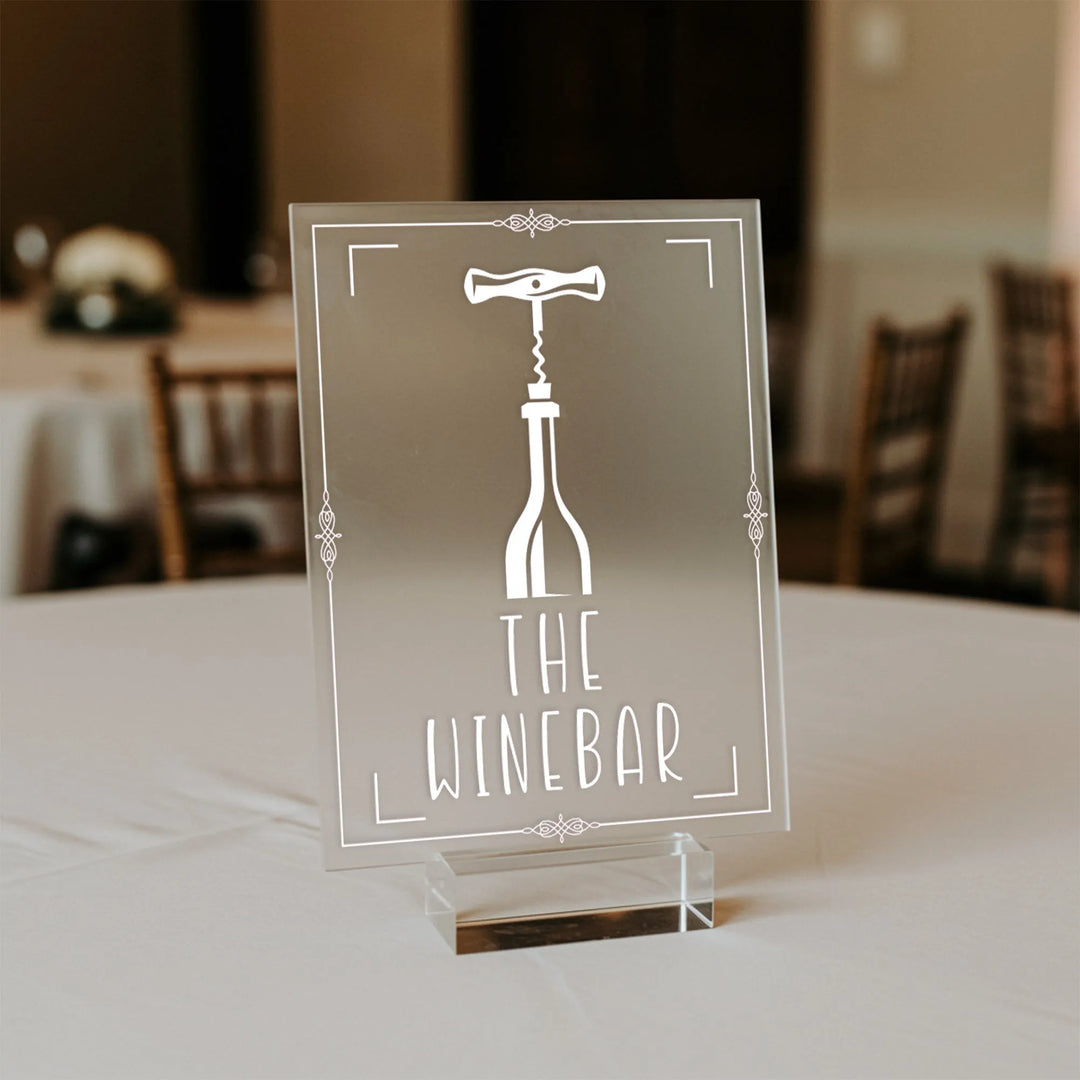 Clear acrylic wedding table sign with wine bottle and corkscrew graphic labeled The Winebar
