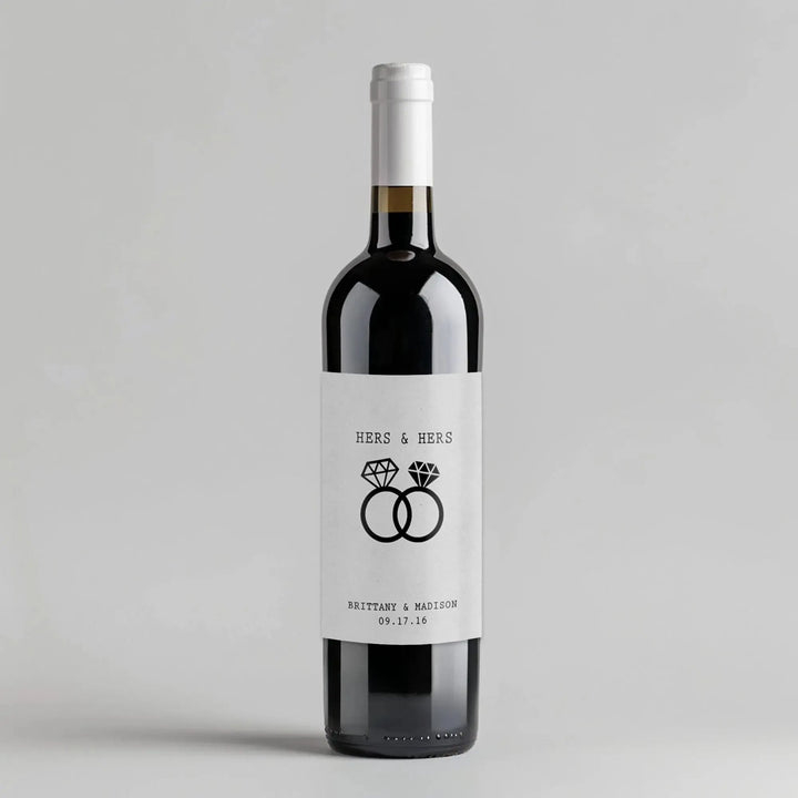 Custom wine bottle with white label, two diamond rings, 'Hers & Hers' text, wedding date.