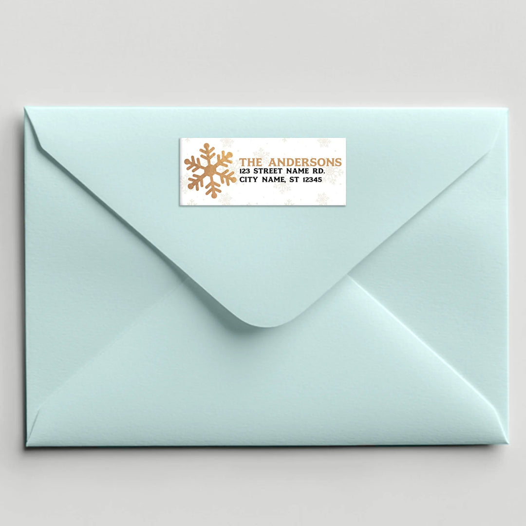 Holiday address label with gold snowflake on light blue envelope