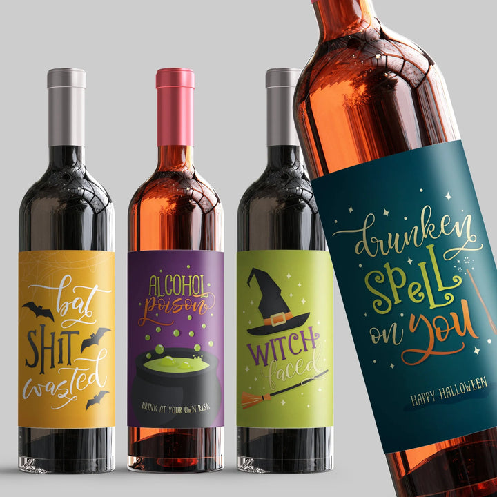 Halloween-themed wine bottles with funny labels featuring bats, witch hat, and cauldron designs.