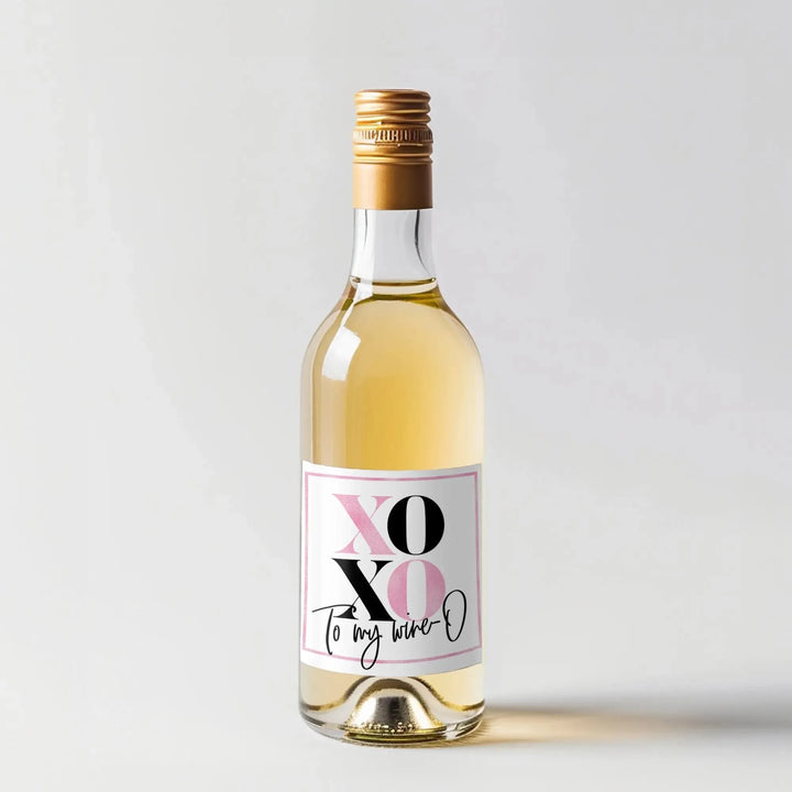 White wine bottle with gold cap and pink XOXO Valentine wine label