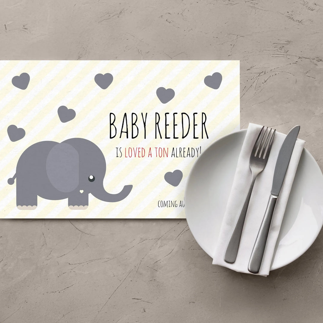 Yellow elephant baby shower placemat with gray hearts and table setting on gray surface