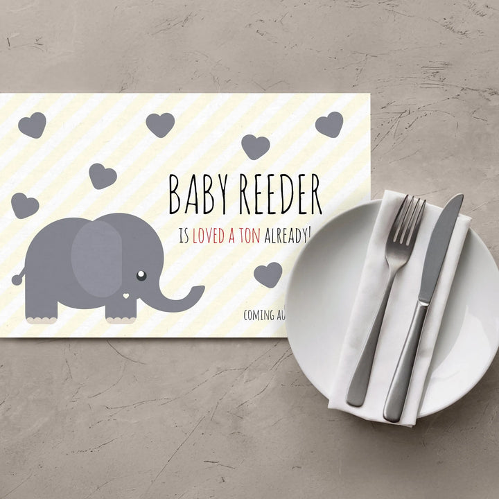 Yellow elephant baby shower placemat with gray hearts and table setting on gray surface