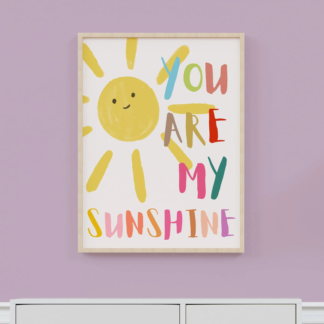 Colorful nursery wall art with a smiling sun and text You Are My Sunshine in playful fonts
